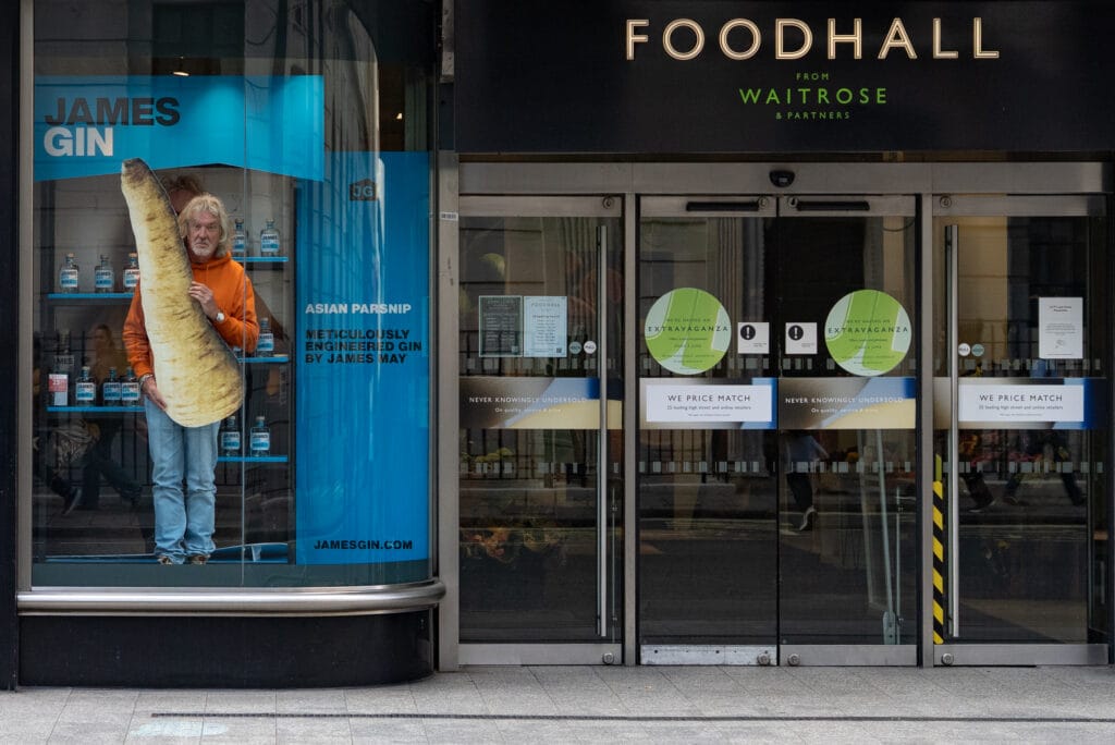 James May of Top Gear and The Grand Tour photographed straddling two giant parsnips to celebrate the launch of his Asian Parsnip Gin in Waitrose Food Hall, in John Lewis Oxford Street